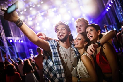 group of friends taking selfie at a concert