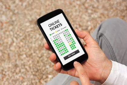 A man uses venue technology to purchase tickets for an upcoming show.