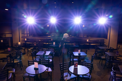 Dimly lit comedy club with table seating